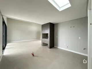 Ambiente interno de uma sala ampla com teto de claraboia.