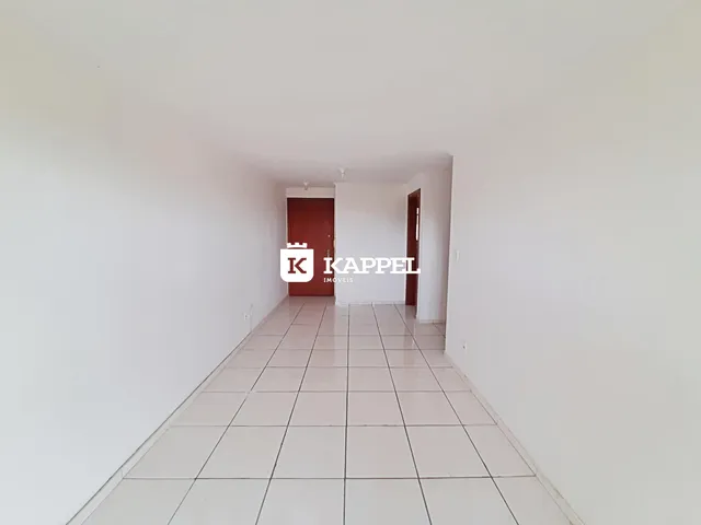 Uma foto de um corredor interno com paredes brancas e piso de cerâmica.