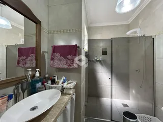 Foto de um banheiro com azulejos brancos e box de vidro.