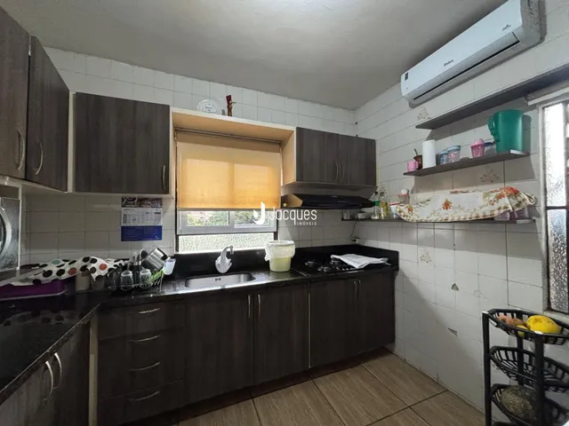 Foto interna de uma cozinha com armários e bancadas em um imóvel no Brasil.