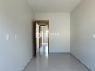Hall de entrada com paredes brancas e piso de cerâmica.