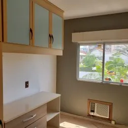 Foto de um interior com armário de madeira e janela.