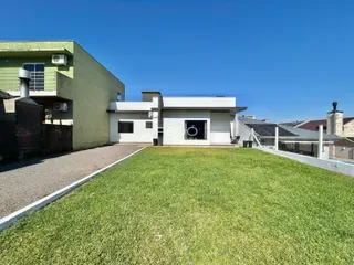 Fachada de uma residência em Lajeado, Brasil, com um grande gramado em primeiro plano.