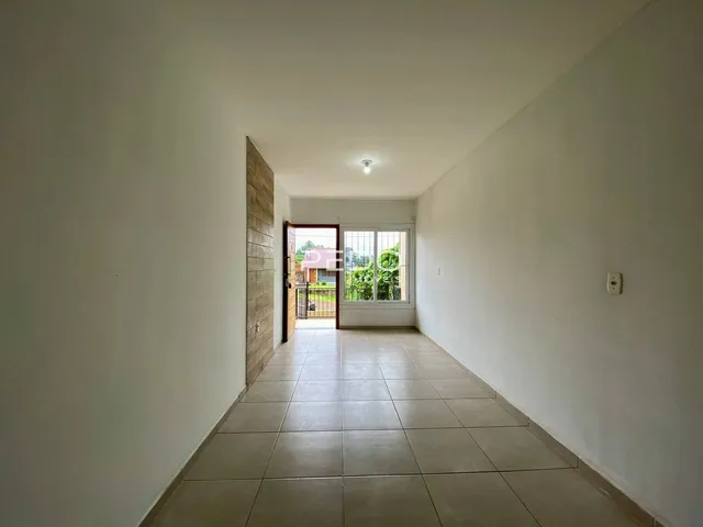 Corredor interno de uma residência com piso de cerâmica clara.