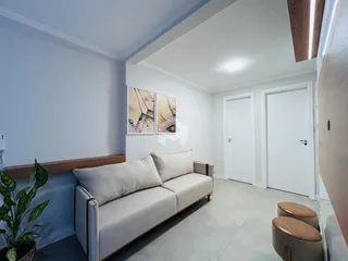 Sala de estar com sofá e paredes brancas.