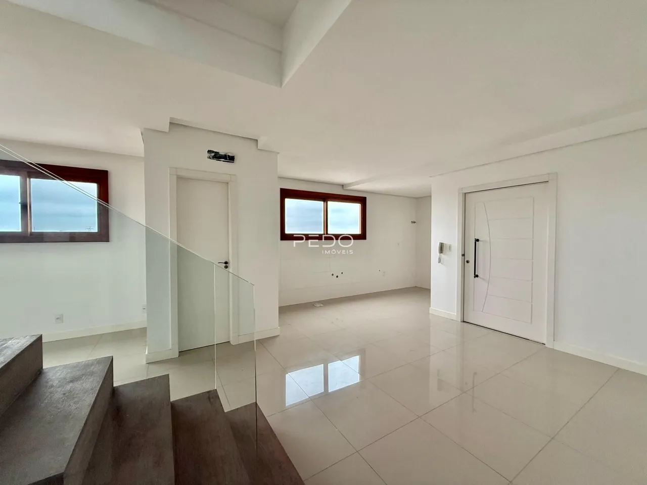 Sala de estar com piso claro e paredes brancas em um imóvel no Brasil.