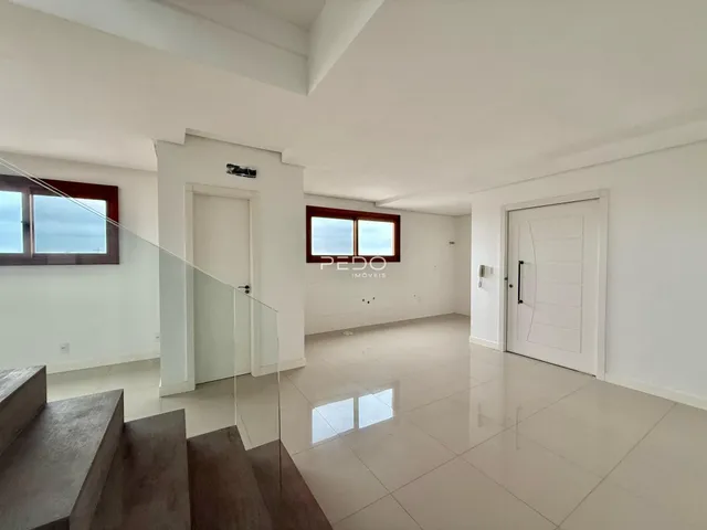Sala de estar com piso claro e paredes brancas em um imóvel no Brasil.