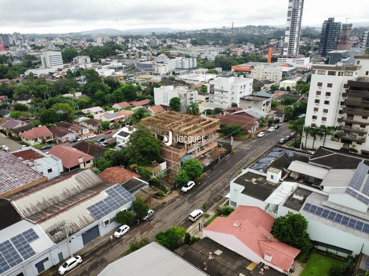 Vista aérea de um conjunto de telhados e edifícios em uma área residencial.