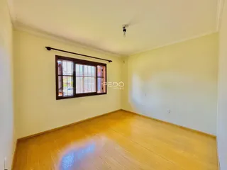 Sala de estar com piso de madeira e janela.