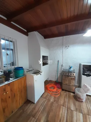 Vista interna de uma cozinha com piso de madeira e teto de madeira.