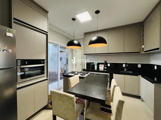 Vista da cozinha moderna com armários e bancadas escuras.