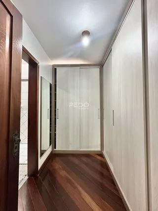 Hall de entrada com piso de madeira e armários embutidos.