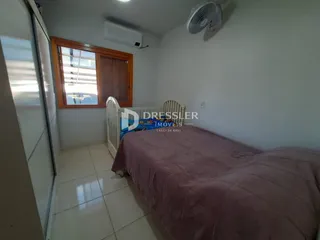 Quarto com cama e janela em ambiente interno.