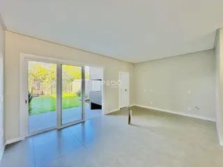 Sala de estar com portas de vidro que dão acesso a um jardim.