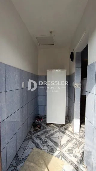 Corredor interno com revestimento de azulejos nas paredes e piso.