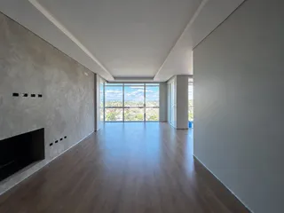 Sala de estar ampla com grandes janelas que oferecem uma vista panorâmica.