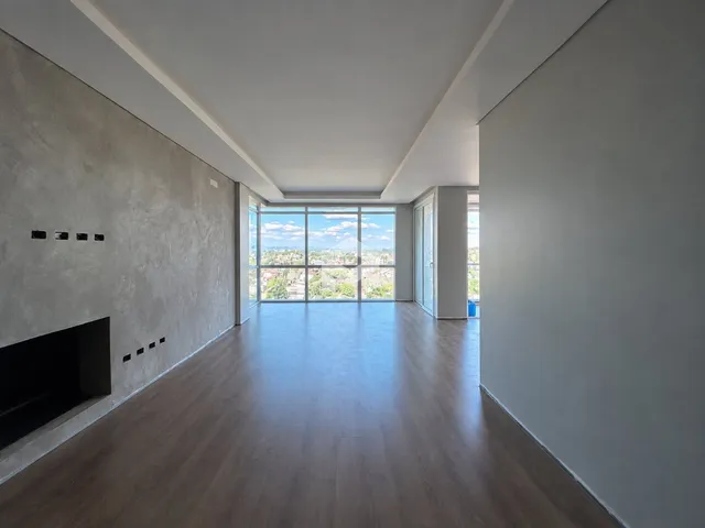 Sala de estar ampla com grandes janelas que oferecem uma vista panorâmica.