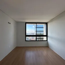 Vista de uma janela mostrando um horizonte urbano.