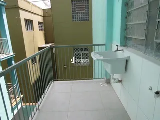 Vista da varanda com piso de cerâmica e pia na parede.