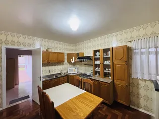Interior de uma sala com móveis de madeira e portas abertas.