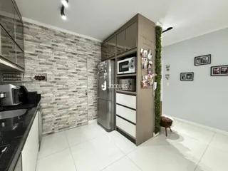 Interior de uma sala de estar com cozinha em um imóvel no Brasil.