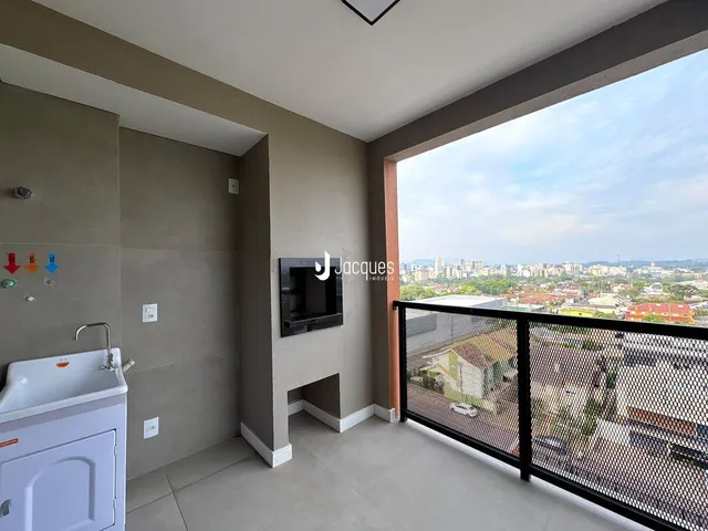 Vista interna de um apartamento com grande janela de vista para a paisagem.