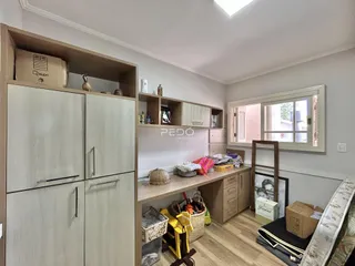 Interior de uma sala com estantes e armários em madeira.