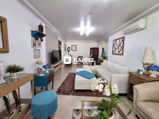 Sala de estar com sofá branco e decoração em um apartamento.