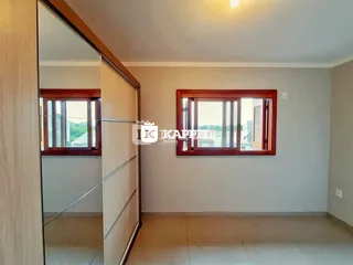 Foto de um interior com parede clara e janela de madeira.