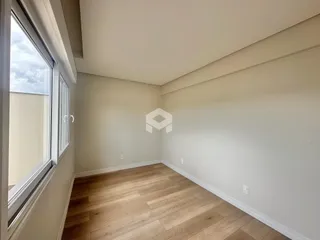 Ambiente interno com piso de madeira e grande janela.