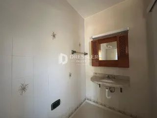 Corredor interno com paredes brancas e decoração de trepadeiras nas paredes.