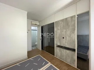Quarto com armários embutidos e piso de madeira em um imóvel em Lajeado.