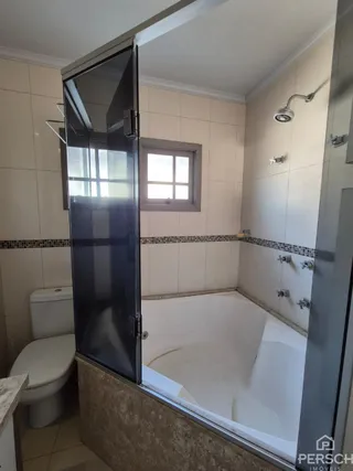 Foto de um banheiro com banheira e janela em uma propriedade em Lajeado.