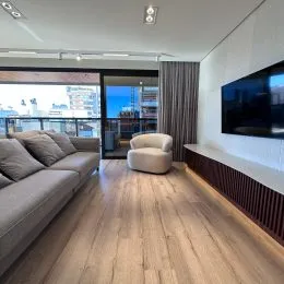 Sala de estar com sofá e vista para o exterior.