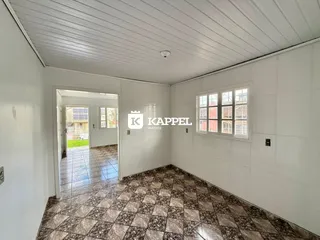 Ambiente interno com piso de mármore e janela em uma residência.