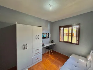 A sala de estar apresenta armários brancos e piso de madeira no imóvel.