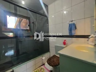 Foto de um banheiro com revestimento cerâmico e vidro.