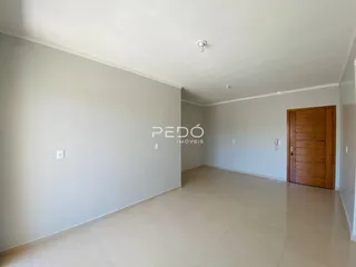 Interior de um ambiente com piso de cerâmica e parede branca.