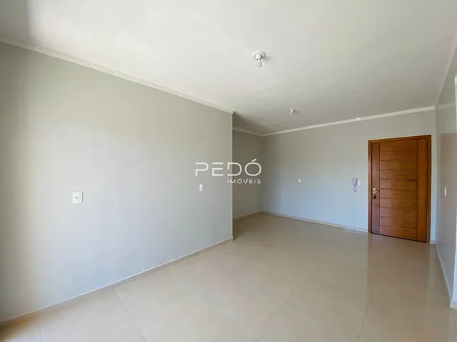 Interior de um ambiente com piso de cerâmica e parede branca.
