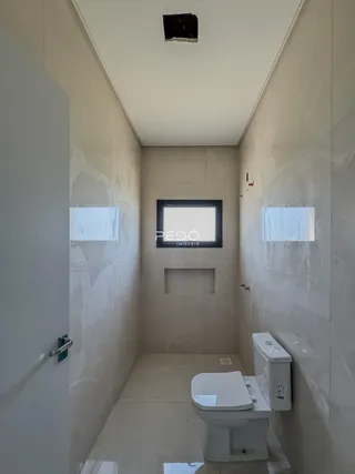 Corredor interno com paredes brancas e piso claro.