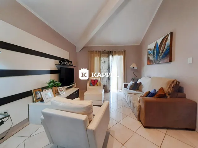 Sala de estar com sofá e poltronas em um ambiente claro.