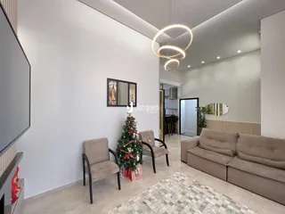 Sala de estar moderna com sofá e decoração de Natal em um imóvel no Brasil.