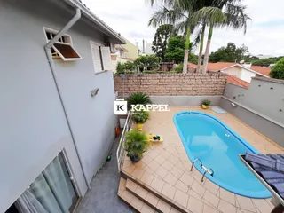 Foto da área externa com piscina e muro de pedra em um imóvel.