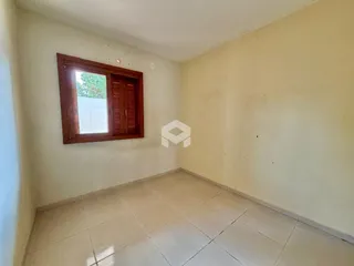 Foto de um cômodo interno com piso de cerâmica e janela de madeira.