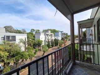 Vista de um bairro residencial com edifícios ao fundo.