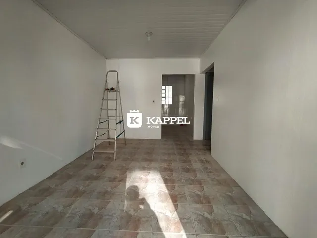 Hall de entrada com piso de cerâmica e escada visível.
