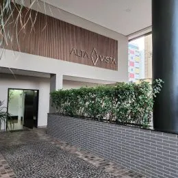 Fachada externa de um imóvel com vegetação verde.
