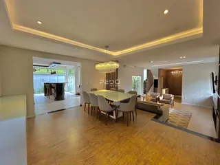 Sala de estar ampla com piso de madeira e iluminação moderna.