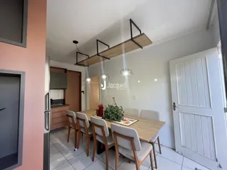 Foto de uma sala de jantar com mesa de madeira e cadeiras em um imóvel no Brasil.