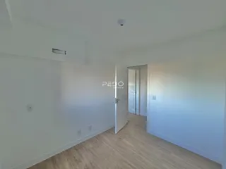 Vista interna de um corredor com piso de madeira clara.
